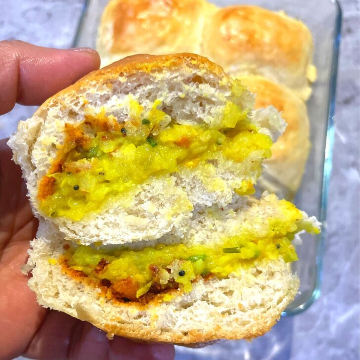 Close up look of Vegan Baked Vada Pav cut into half and the inside filling and texture seen.