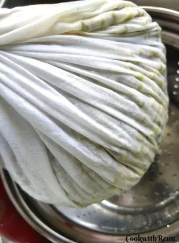 Soaked Mung Beans getting tied in a white muslin cloth for making sprouts.