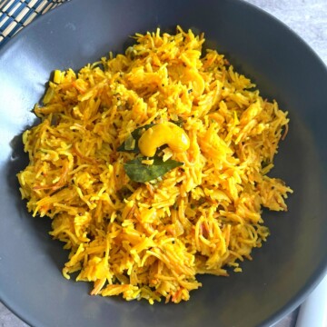Tomato Sevai served in a grey plate, with a black and blue mat seen in the background.