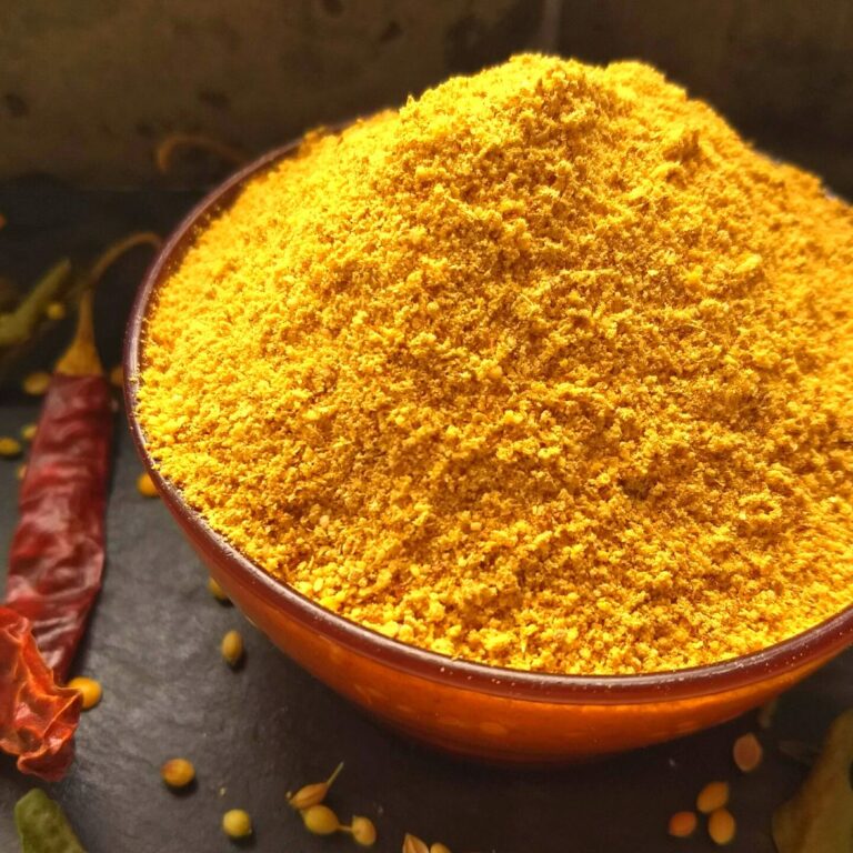 Easy Sambhar masala in a bowl with some spices scattered around.