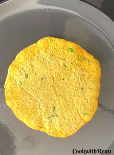 Bajra Chives paratha being cooked on the bottom.