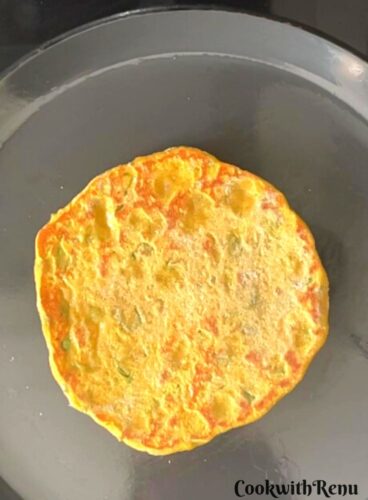 Bajra Chives paratha being cooked on the other side.