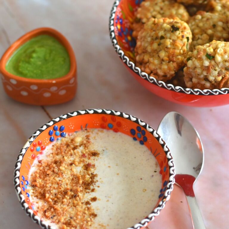 Farali Singdana Raita served in a designer orange bowl, with some air fryer sabudana vada and green chutney on the side.
