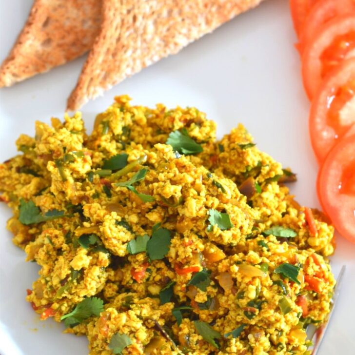 Indian-Style Tofu Scramble served on a white plate with 2 bread slices.