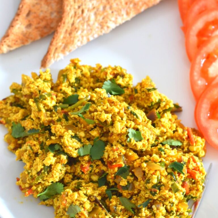 Indian-Style Tofu Scramble served on a white plate with 2 bread slices.