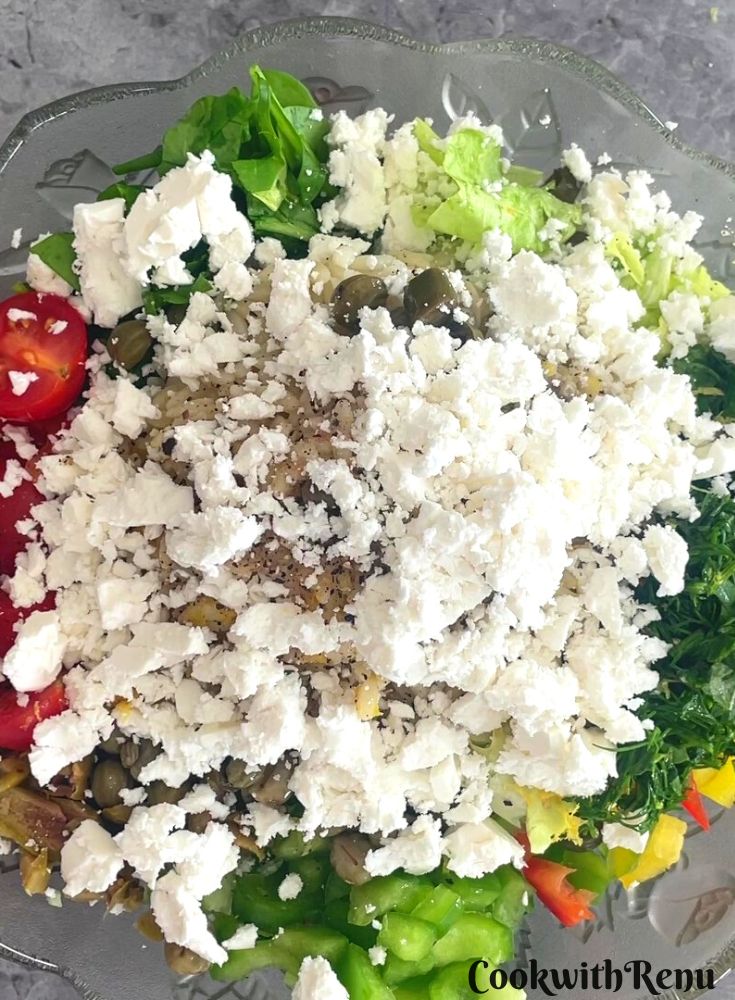 Adding of feta cheese in vegetable and pasta in a bowl.