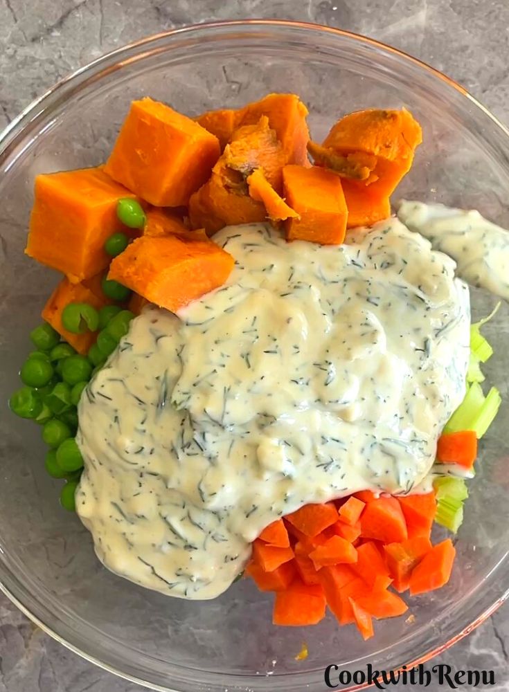 Dressing added to Salad in a transparent glass bowl.
