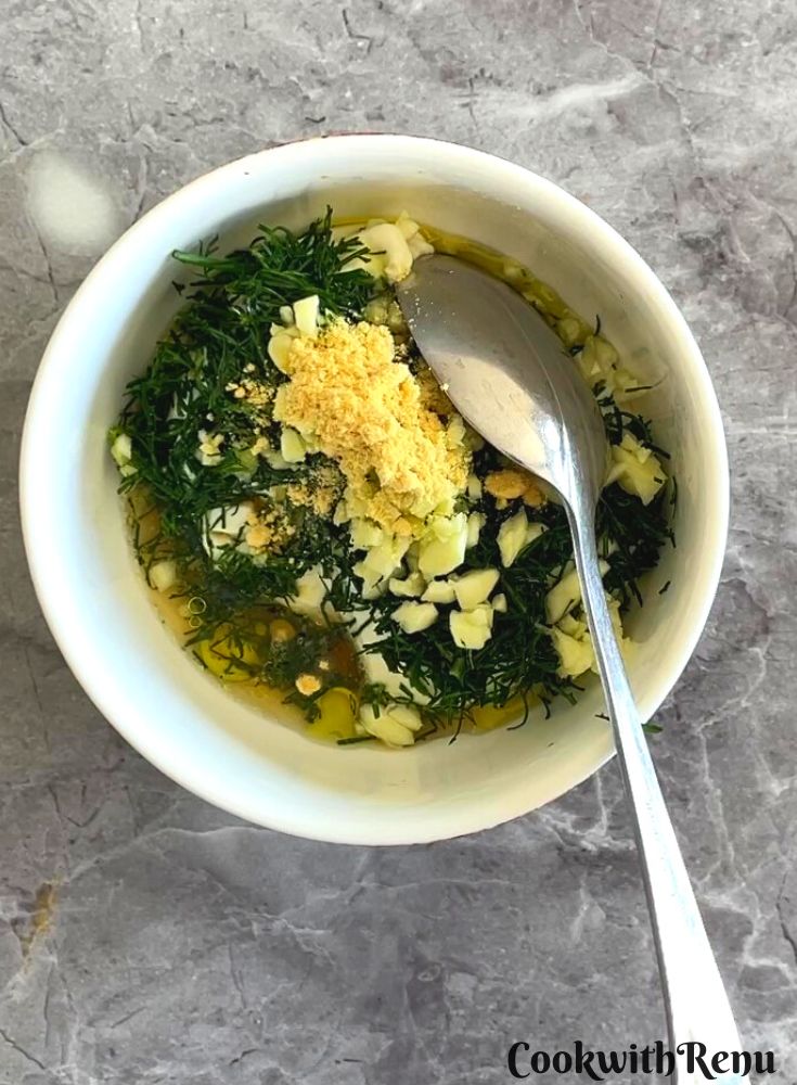 Yogurt, fennel fronds, garlic and mustard in a bowl.