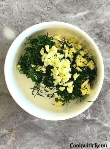 Yogurt, minced fennel fronds, garlic in a bowl