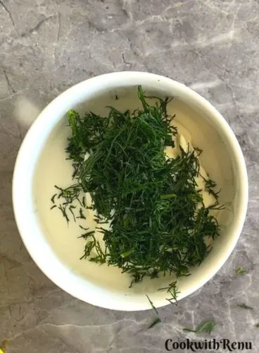 Yogurt, minced fennel fronds in a bowl,