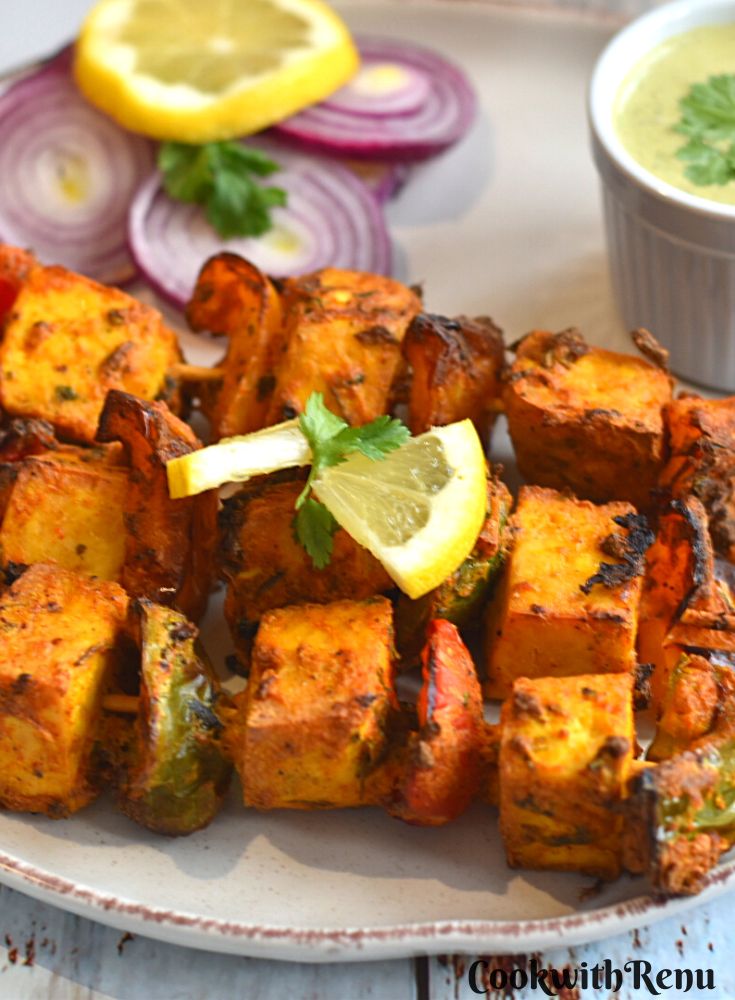 Vegan Tofu Tikka served in a plate along with onion and mint chutney.