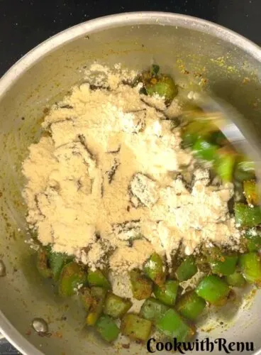 Besan/Gram flour added to Shimla Mirch in a pan.