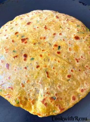 Cooking of the Zucchini paratha on the bottom.