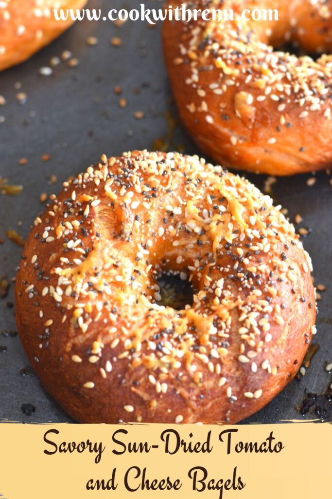 Baked Savoury Bagels topped with cheese and sesame seeds on a baking tray.