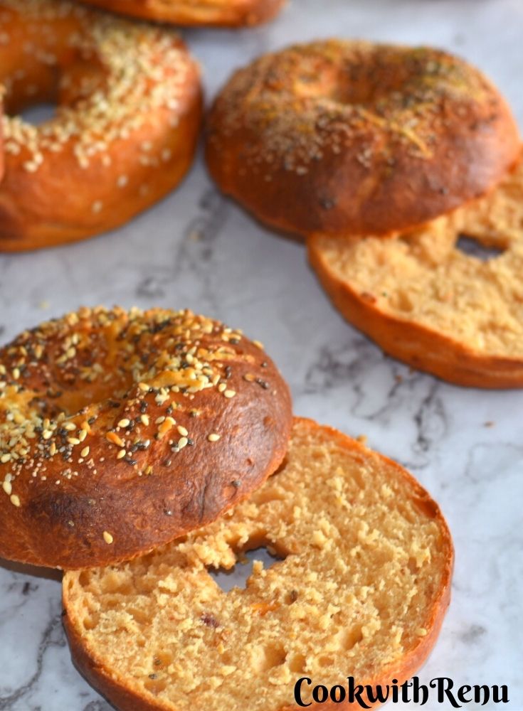Close up look of cut Bagel to see the texture of Sun Dried Tomato Bagels. Seen in the background are few more bagels.