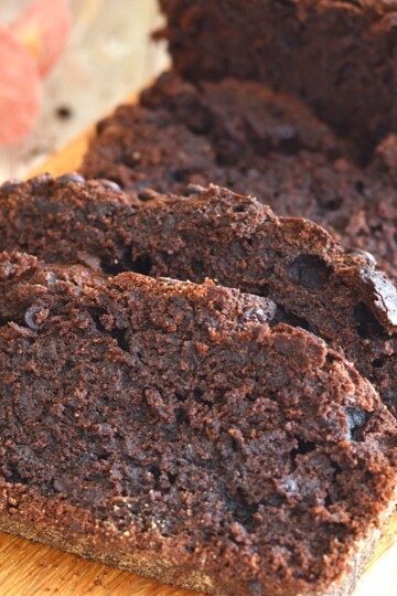 Slices of close up texture of double Chocolate Whole Wheat Banana Bread on a brown board.