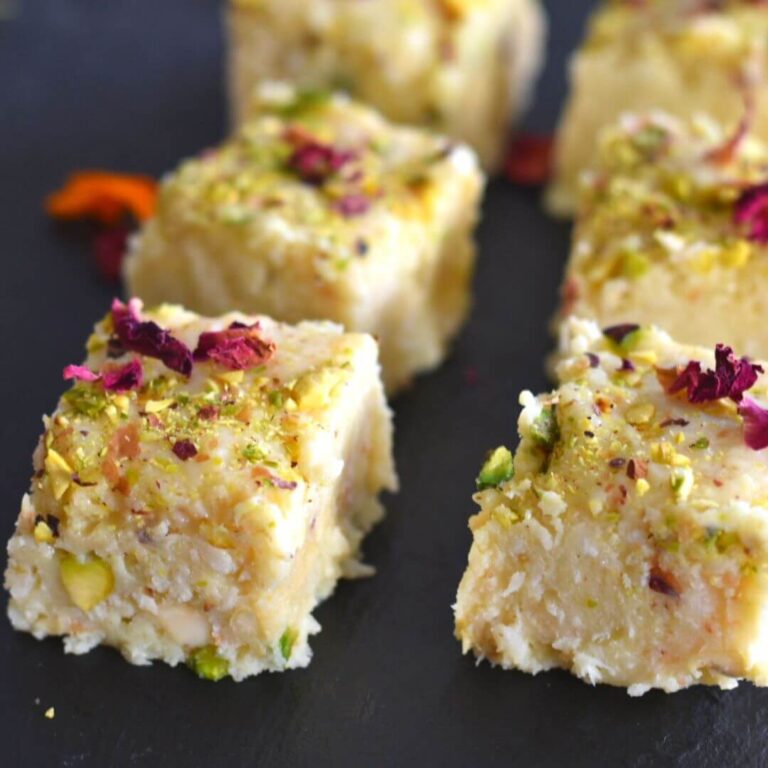 Close up view of Instant Desiccated Coconut Barfi arranged on a black cheese board.