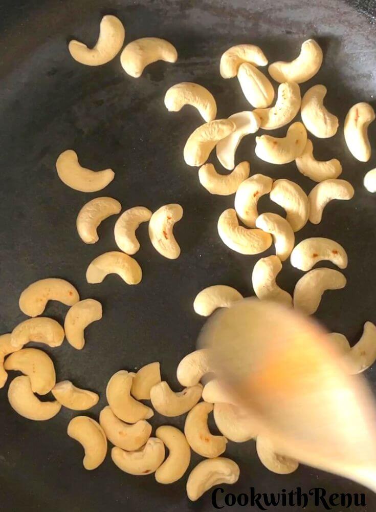 Roasting of cashews in a pan.