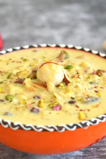 Phool Makhana Kheer served in an orange designer bowl. Seen in the background is some makhana and a candle.