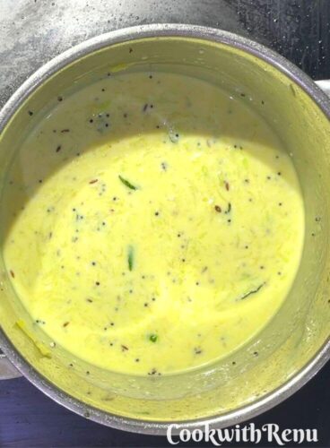 Adding of Yogurt in dudhi mixture in a pot.