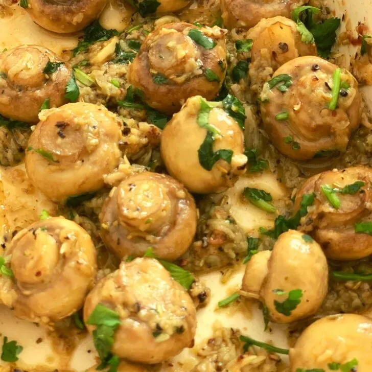 Close up look of Garlic herb roasted mushrooms in a baking tray.