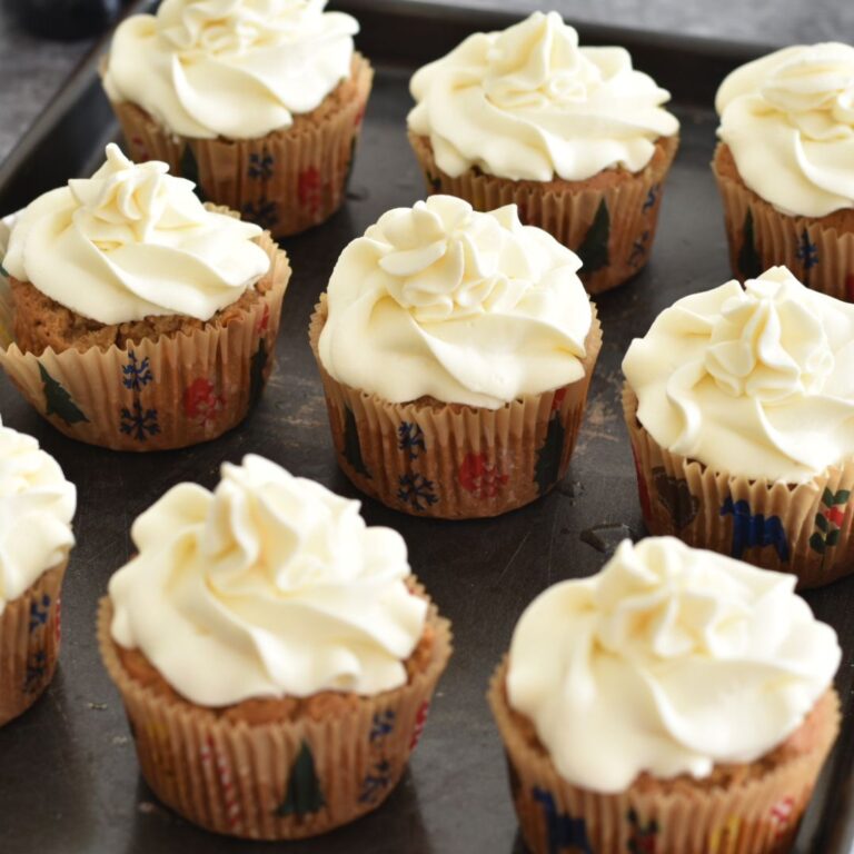 A tray of eggless and Vegan Vanilla Cupcakes on a grey board.