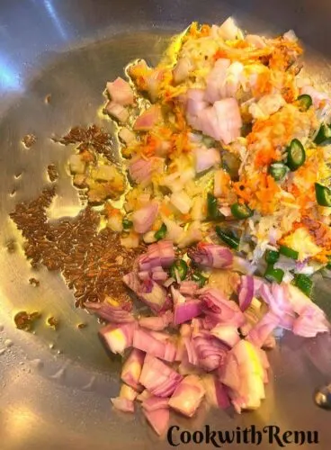 Adding of onion, garlic, giner, turmeric and green chili in oil