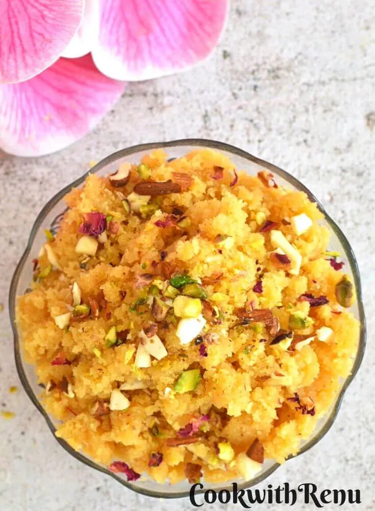 Top view of Rava or Sooji Halwa or Sheera. Seen in the background are some flowers.