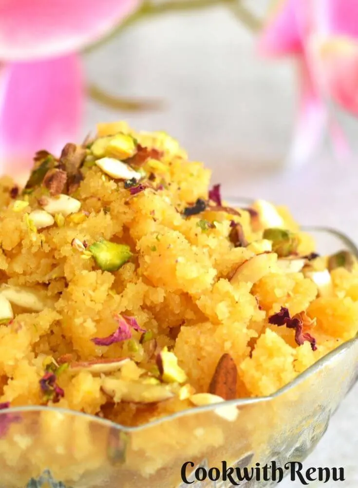 Close up look of Rava or Sooji Halwa or Sheera. Seen in the background are some flowers.