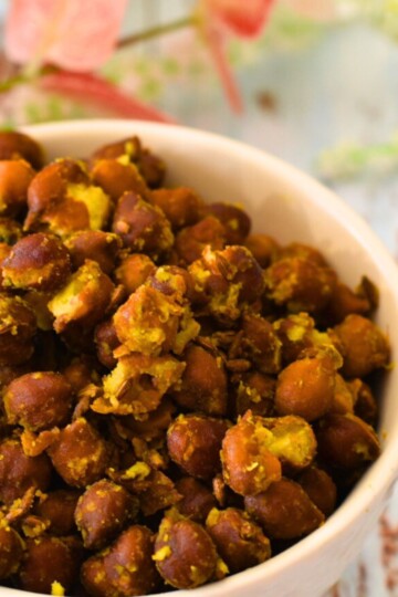 Sukhe Kale Chana is served in a white bowl. Some flowers are seen in the background
