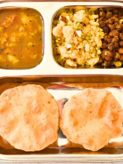 Navratri Ashtami /NavamiThali in a steel plate, with puri, halwa, channa, and aloo sabji.