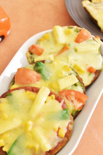 3 small, Gluten-Free Millet flour or Gluten-free Grain Pizza served in a white rectangular plate.