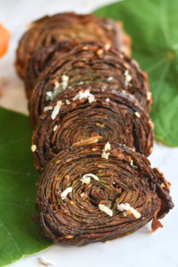 Close-up look of Nasturtium leaves patra, with some leaves and flowers in the background.