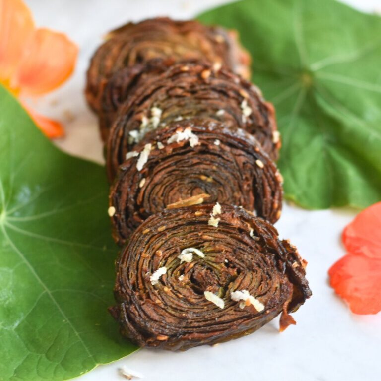Close-up look of Nasturtium leaves patra, with some leaves and flowers in the background.