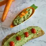 Carrot Greens Tofu Dip in an orange carrot shape plate. Seen in the background is a bread with tofu spread on it and few carrot and bread slices in basket.