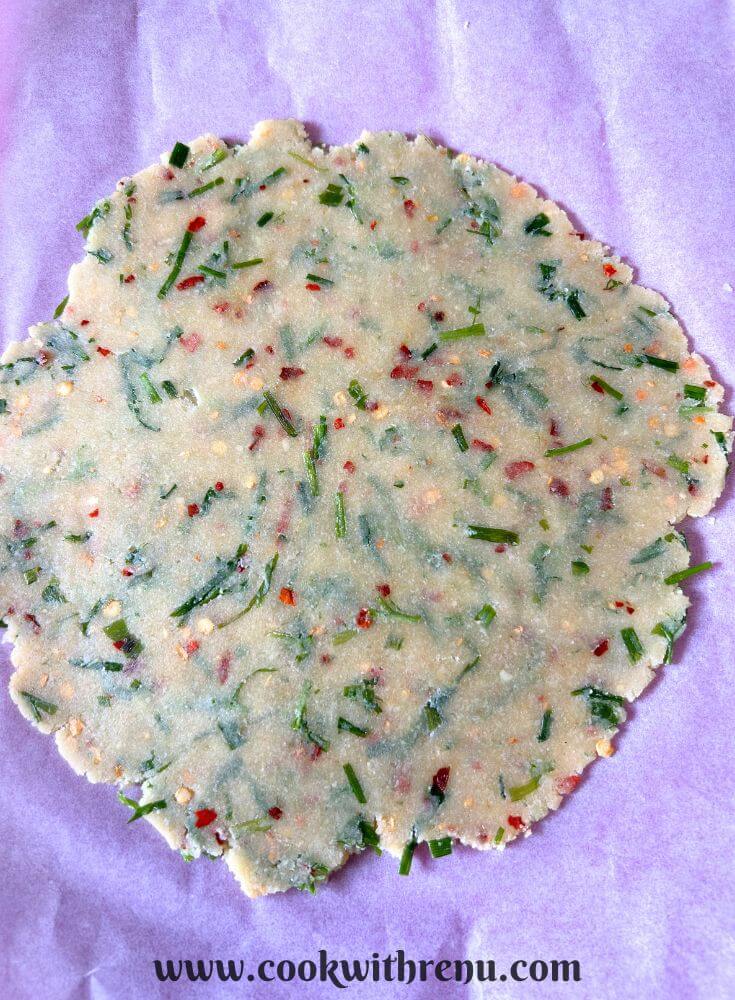 Cracker dough rolled on a parchment paper.