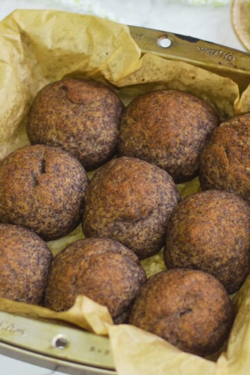 Gluten Free Buckwheat dinner rolls in a 9 inch baking tray with some guacamole on the side.