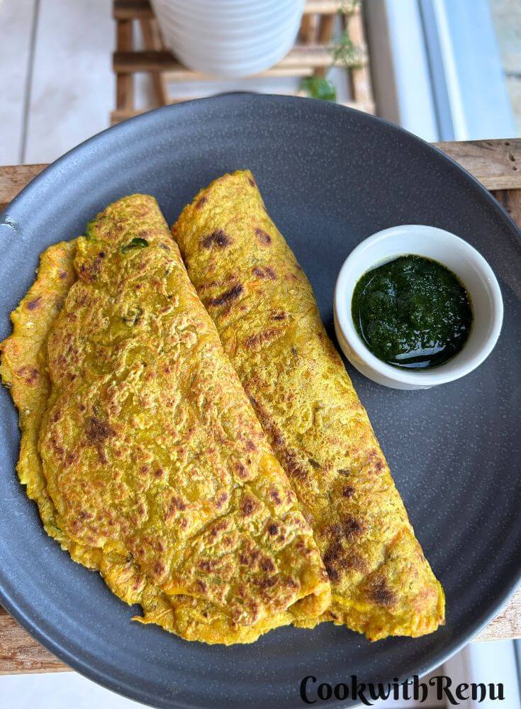 Oats Vegetable pancake served in a blue plate with some chutney on side.