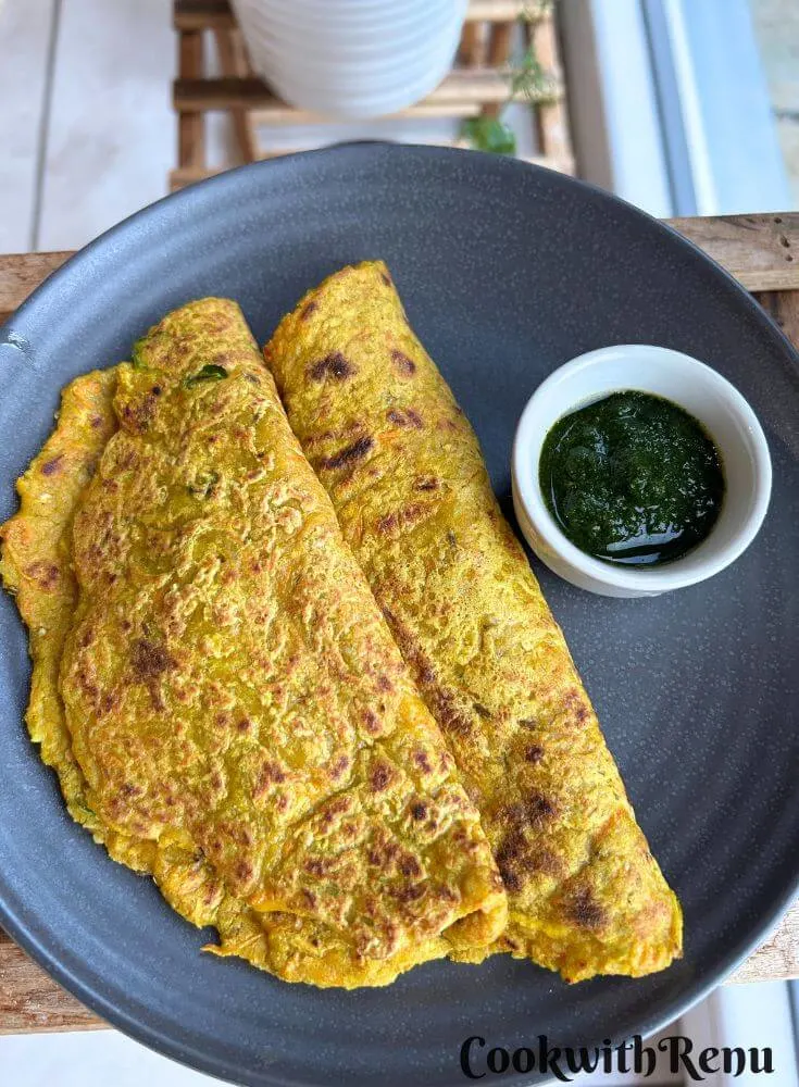 Oats Vegetable pancake served in a blue plate with some chutney on side.