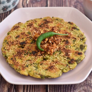 Beet Greens, Carrot, Jowar Thalipeeth served in a pink hexagon plate.