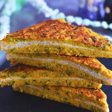 Cut Slices of Moong Dal toast layered on a black cheese board.