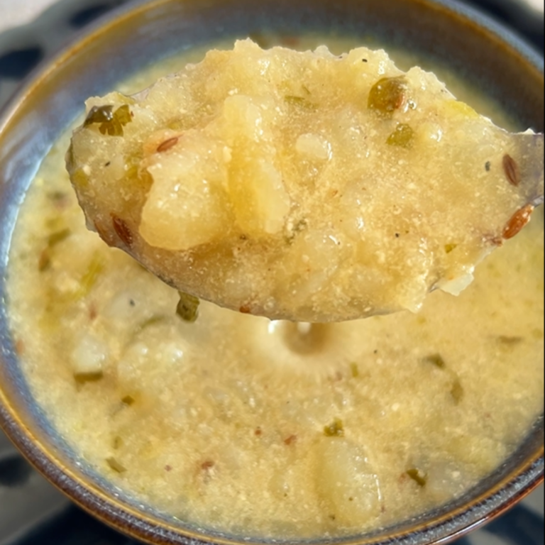 Close up look of dahi aloo seen in a spoon.