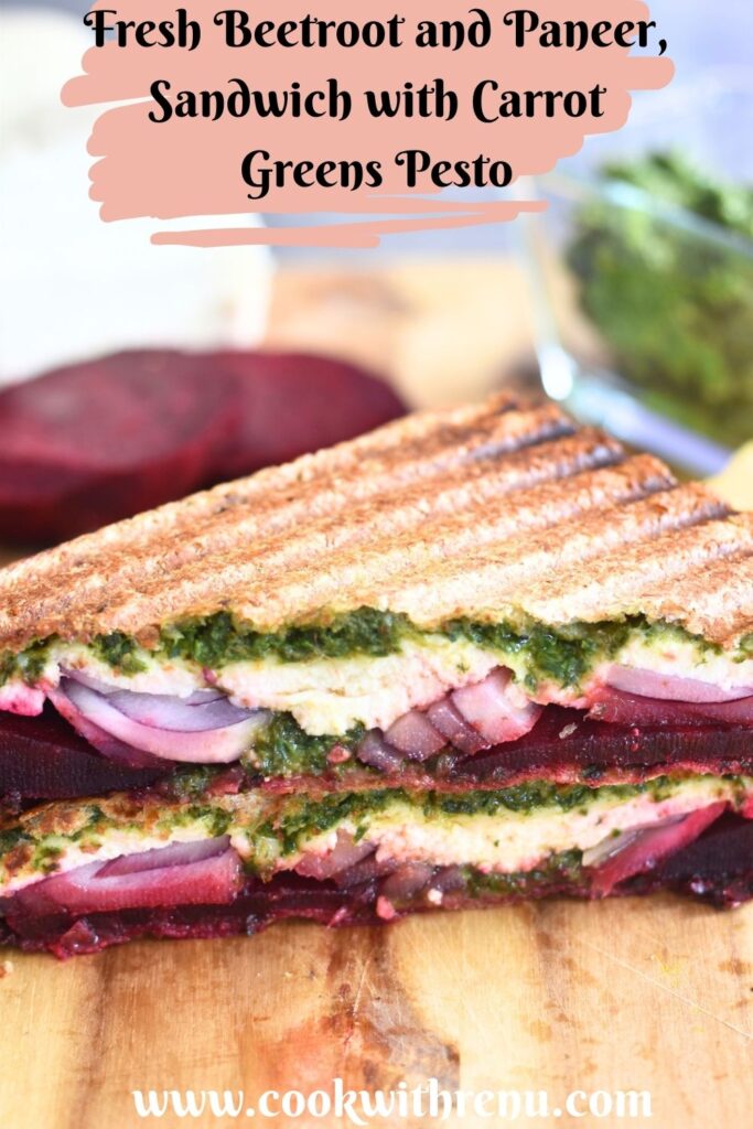 Close up look of Carrot Greens Pesto Beetroot Paneer Sandwich, which is cut open. Seen are the layers of pesto, paneer, onion and beetroot.
