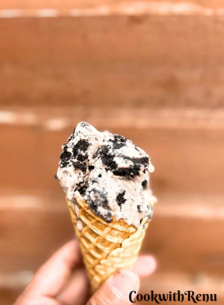 No Churn Oreo Ice Cream served in a waffle cones and hold in hand.