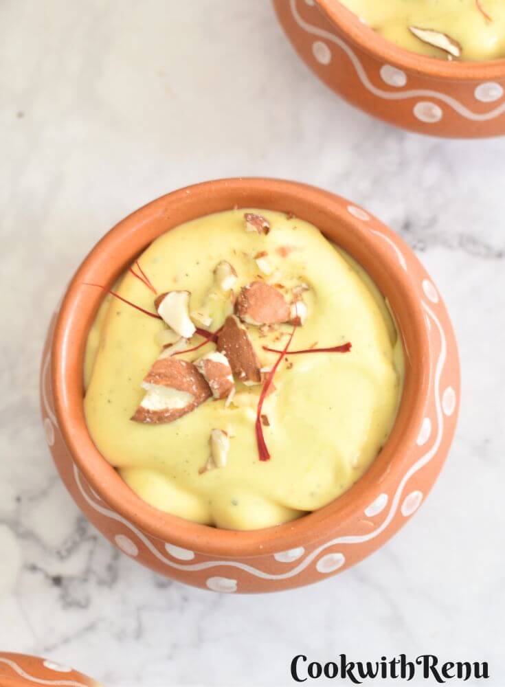 Kesar Almond Shrikhand served in a brown bowl with a garnish of almonds and saffron.