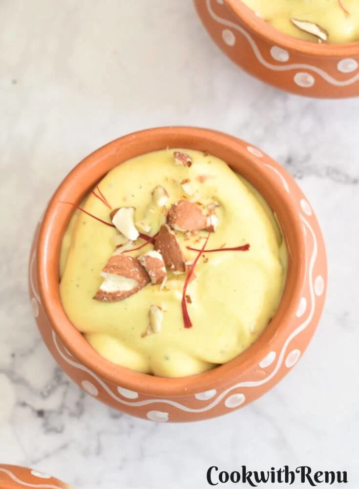 Kesar Almond Shrikhand served in a brown bowl with a garnish of almonds and saffron.