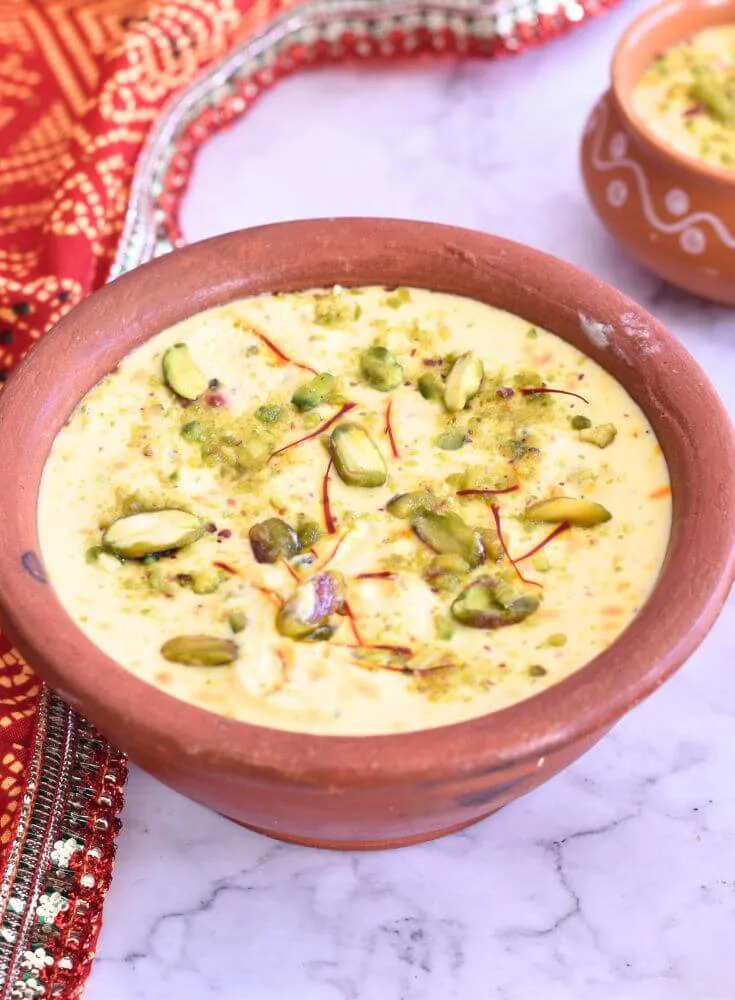 Kesar Pista Shrikhand served in a Kulhad with a garnish of pista and saffron.