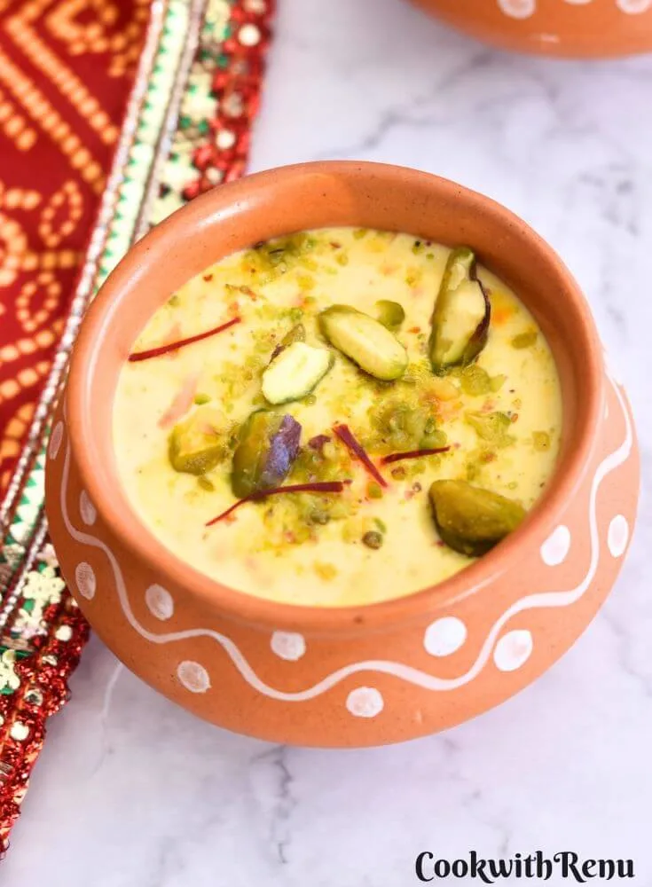 Kesar Pista Shrikhand served in a brown bowl with a garnish of pista and saffron.