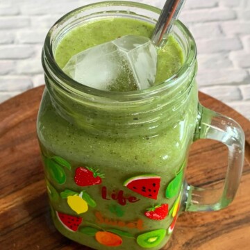 Side view of a Vegan Smoothie served in a glass along with a straw.