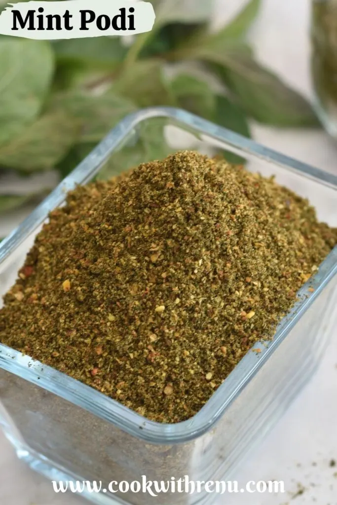 Mint Podi in a rectangular glass bowl. Seen in the background is some mint leaves.